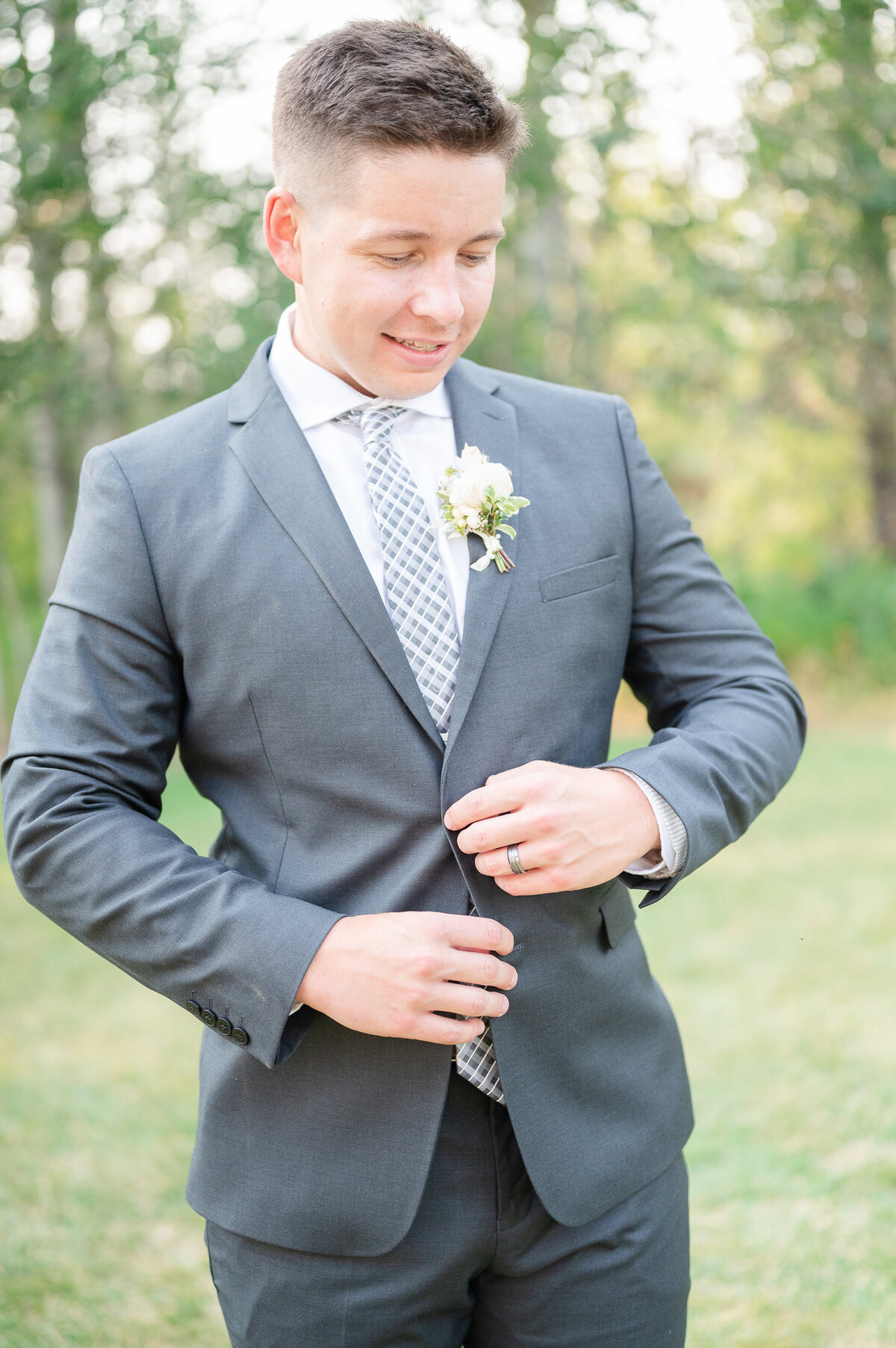 groom buttoning his suit