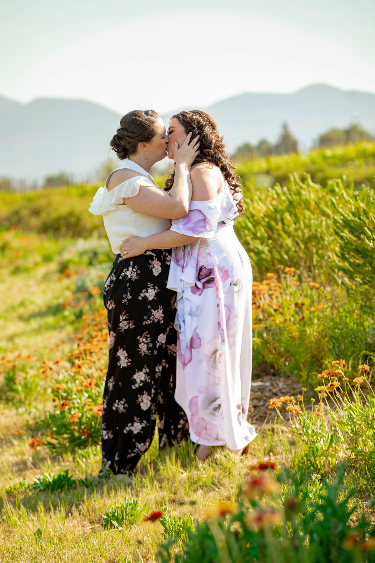 Two people kissing in a field.