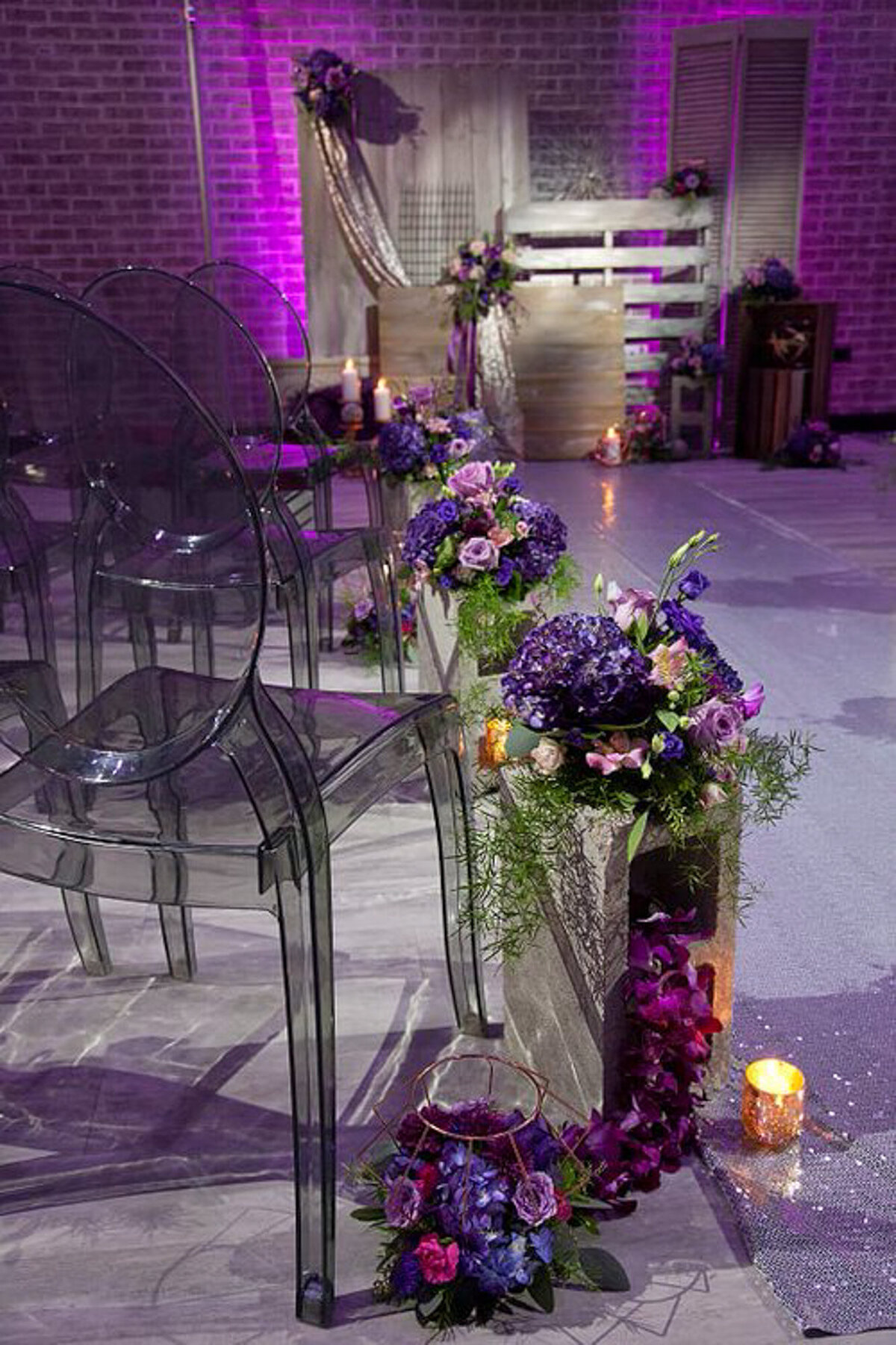 Wedding ceremony site with transparent chair and florals in purple