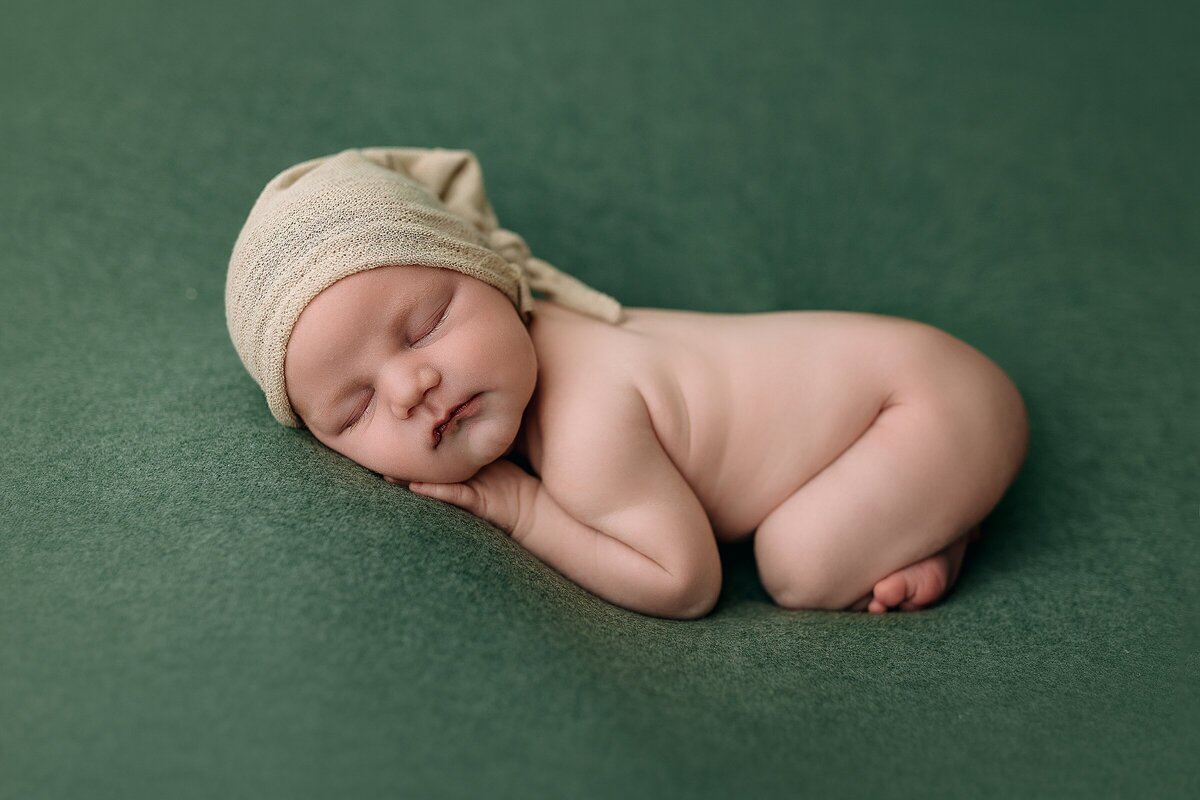 newborn boy on green at photography studio in Harrisonburg, VA