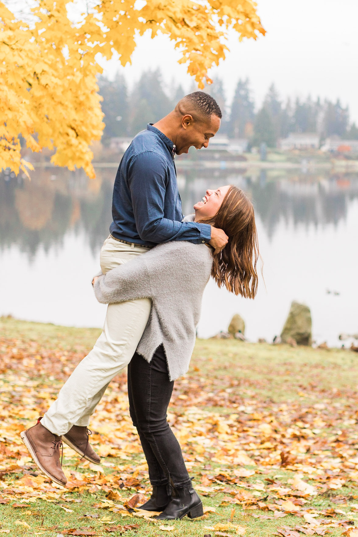 Fun silly fall engagement photos by misty lake with autumn colored trees in Snohomish near Woodinville WA photo by Joanna Monger Photography