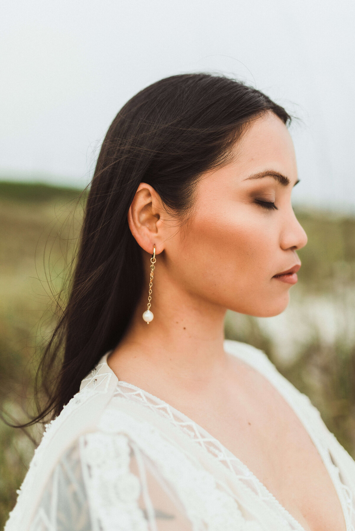 closeup of asian bride in bridal dress and veil on beach path - taken by panama city fl photographer Brittney Stanley