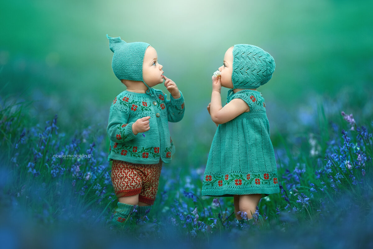 Babies dressed in nostalgic knits playing in bluebells.