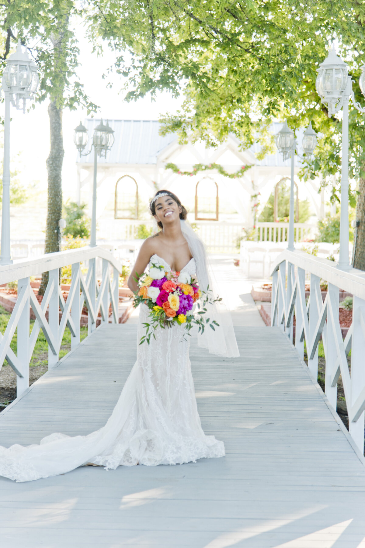 Bride standing on beautiful bridge with colorful bouquet in Fort Worth