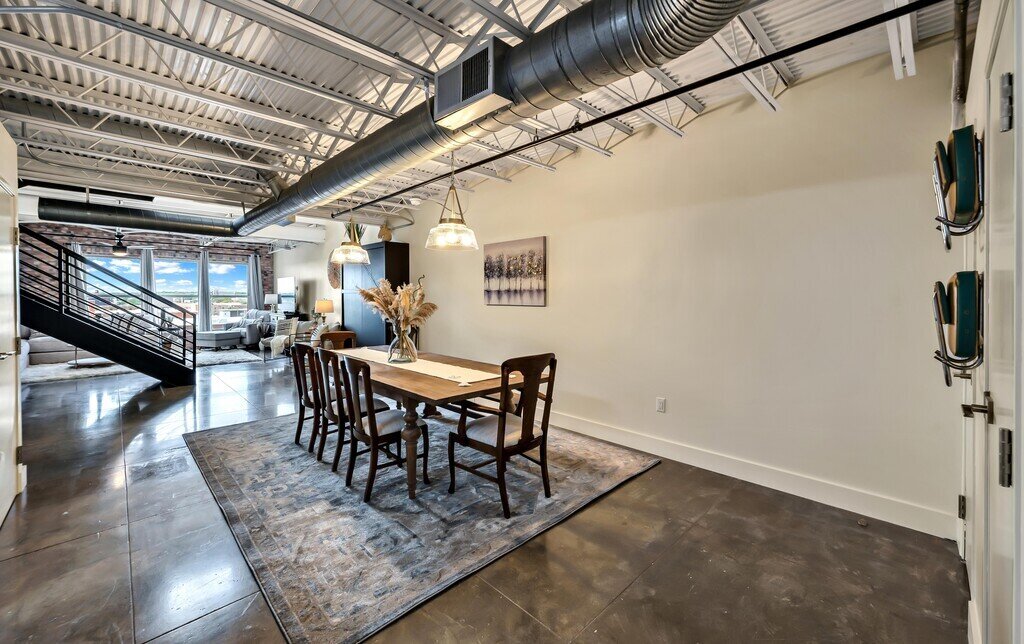 Beautiful dining room table that seats eight in this 2 bedroom, 2.5 bathroom luxury vacation rental loft condo for 8 guests with incredible downtown views, free parking, free wifi and professional decor in downtown Waco, TX.