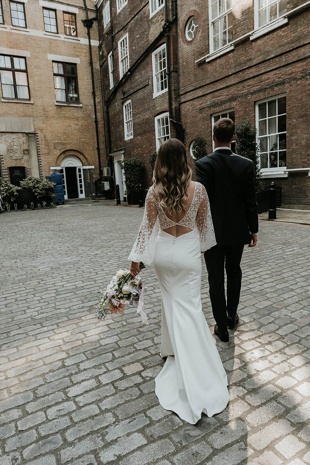 Bride and groom walking outside The Brewery London