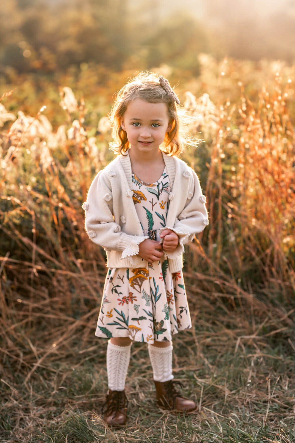 An adorable girl in a fall dress with knee socks and brown boots