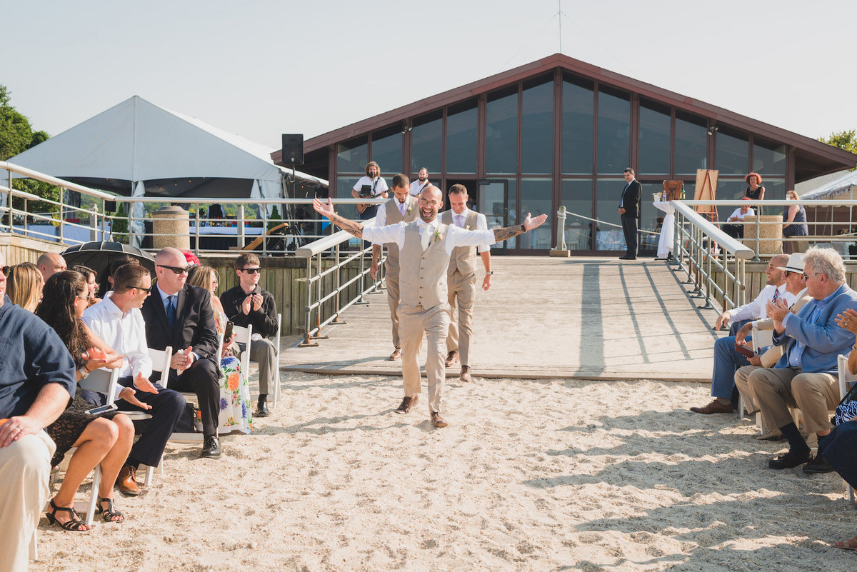 photo of grooms walking down the aisle during wedding ceremony on the beach at Pavilion at Sunken Meadow