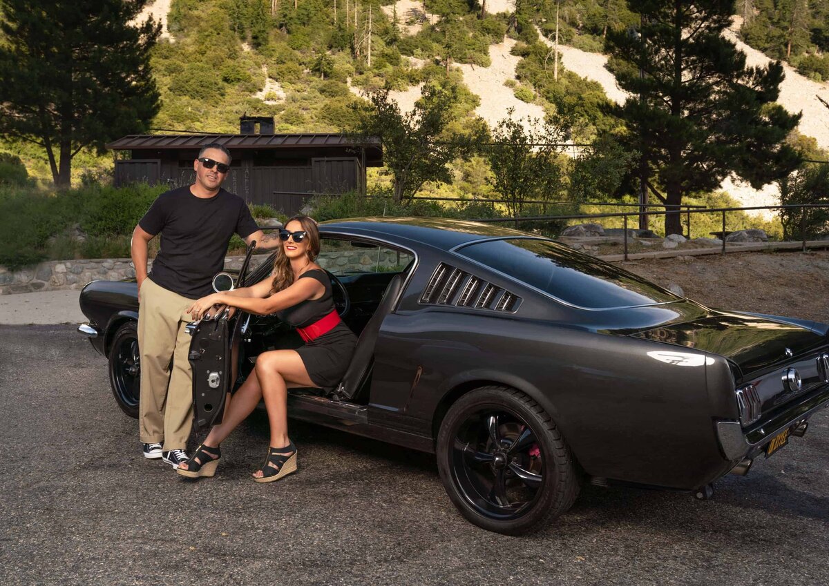 Firefighter couple posing with cloassic black Mustang-1