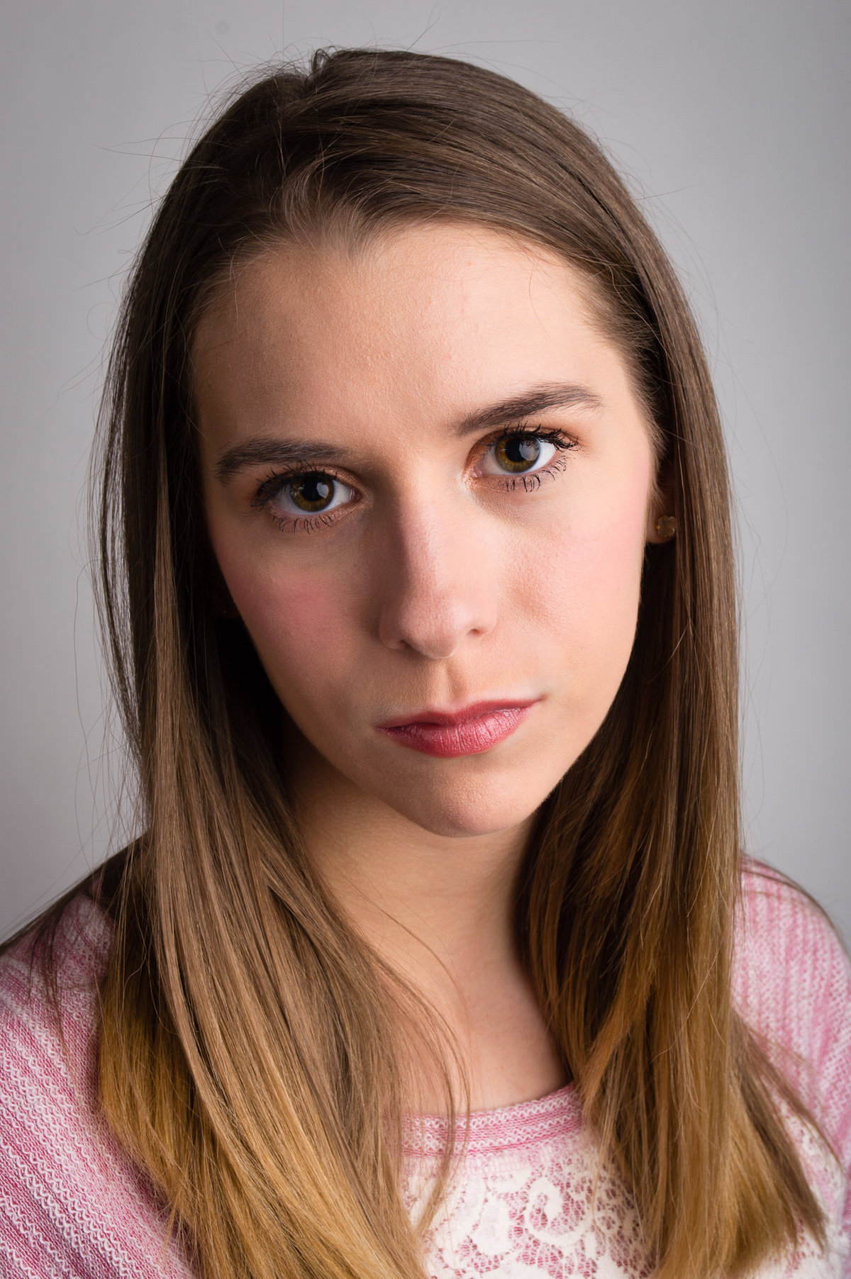 Modeling headshot of a young adult with a grey background