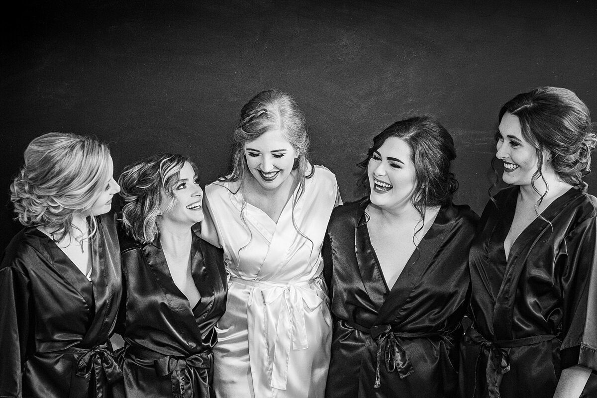 black and white images of bridal party in robes laughing