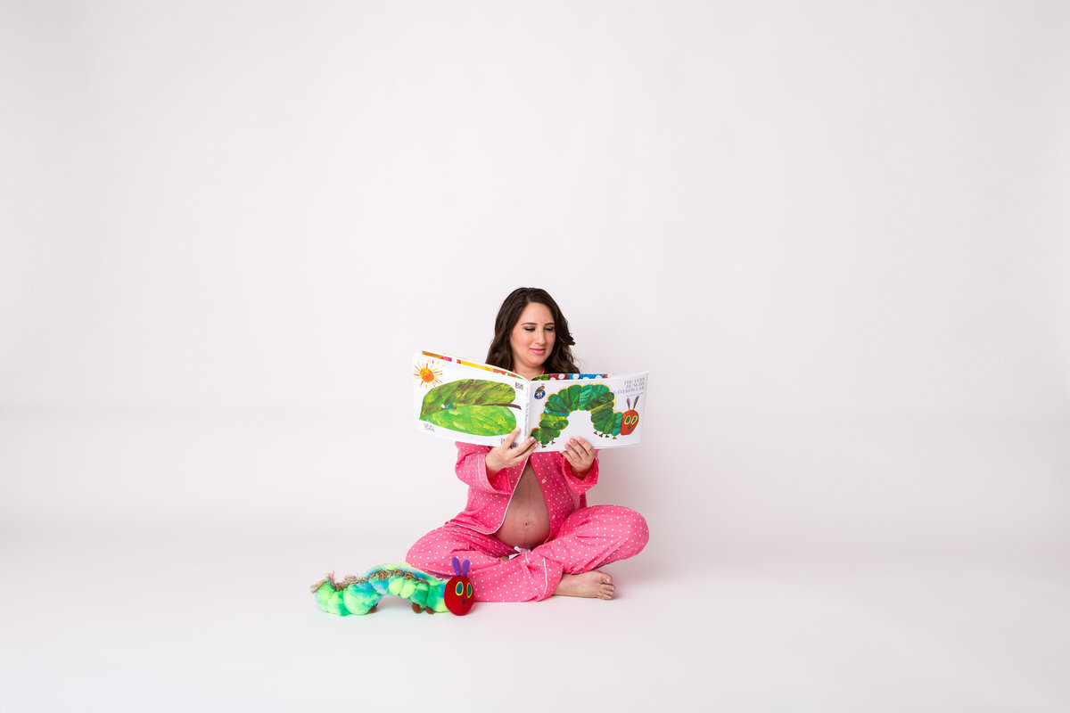 Hungry Caterpillar themed maternity photography session in studio on white backdrop in San Antonio.