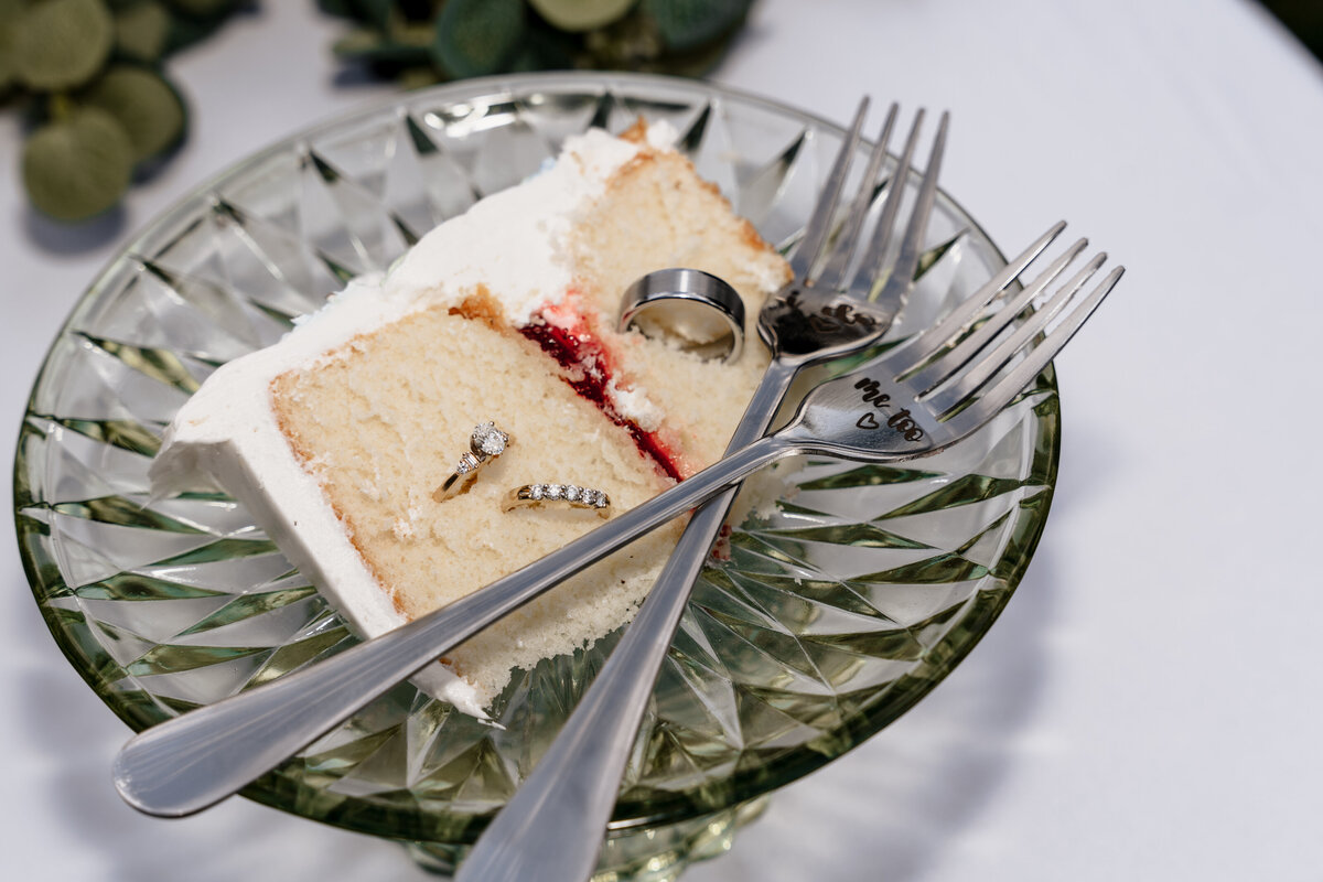 The wedding rings are displayed within a slice of cake.
