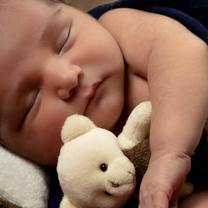 Close up photo of baby Miguel hugging his teddy bear