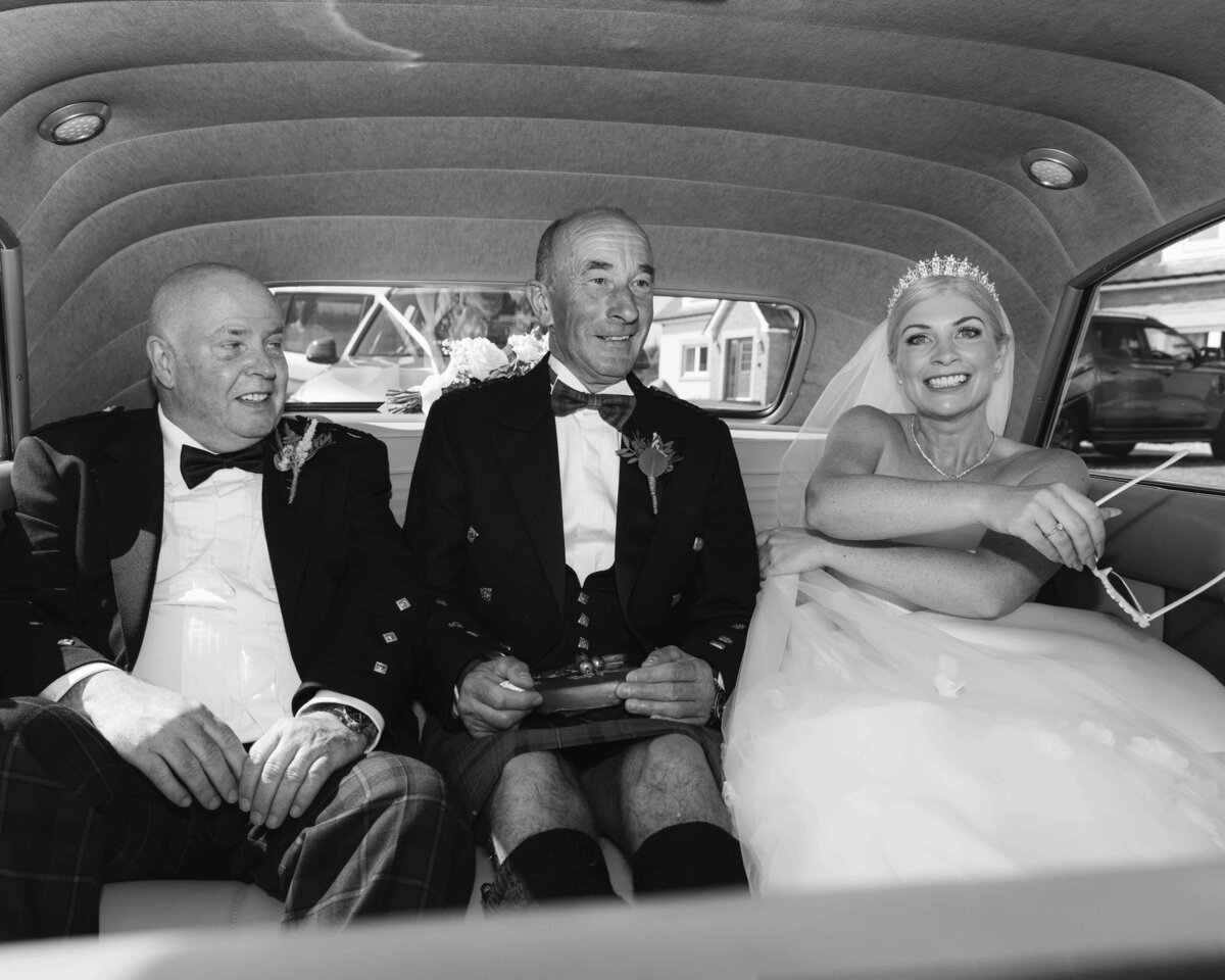 Bride in Cadillac with dad and step dad