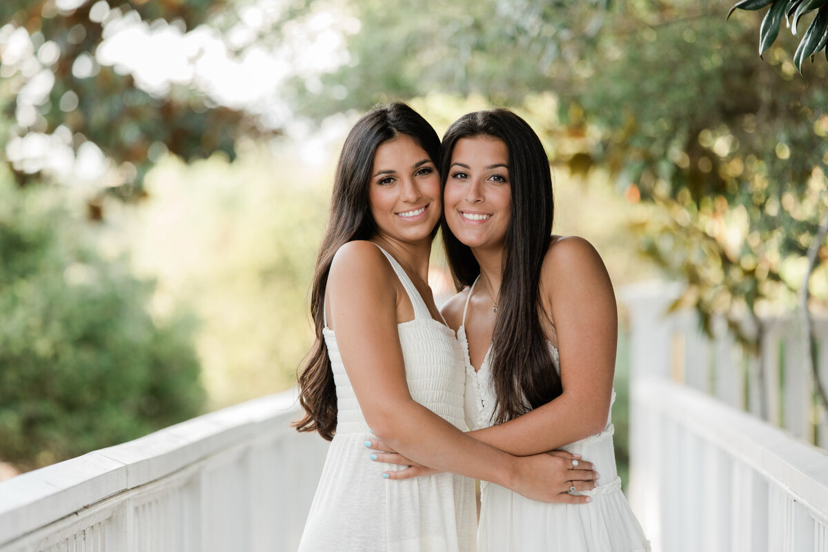 Two siblings standing cheek to cheek smiling