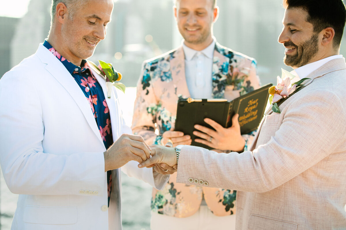 A person putting a ring on their partner at their wedding.