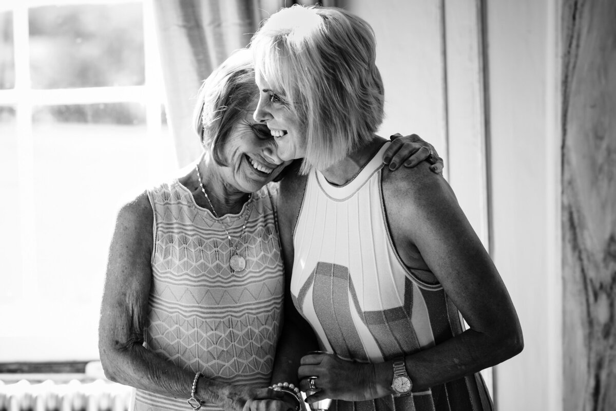 mother and grandmother of the bride embracing during bridal prep at gosfield hall