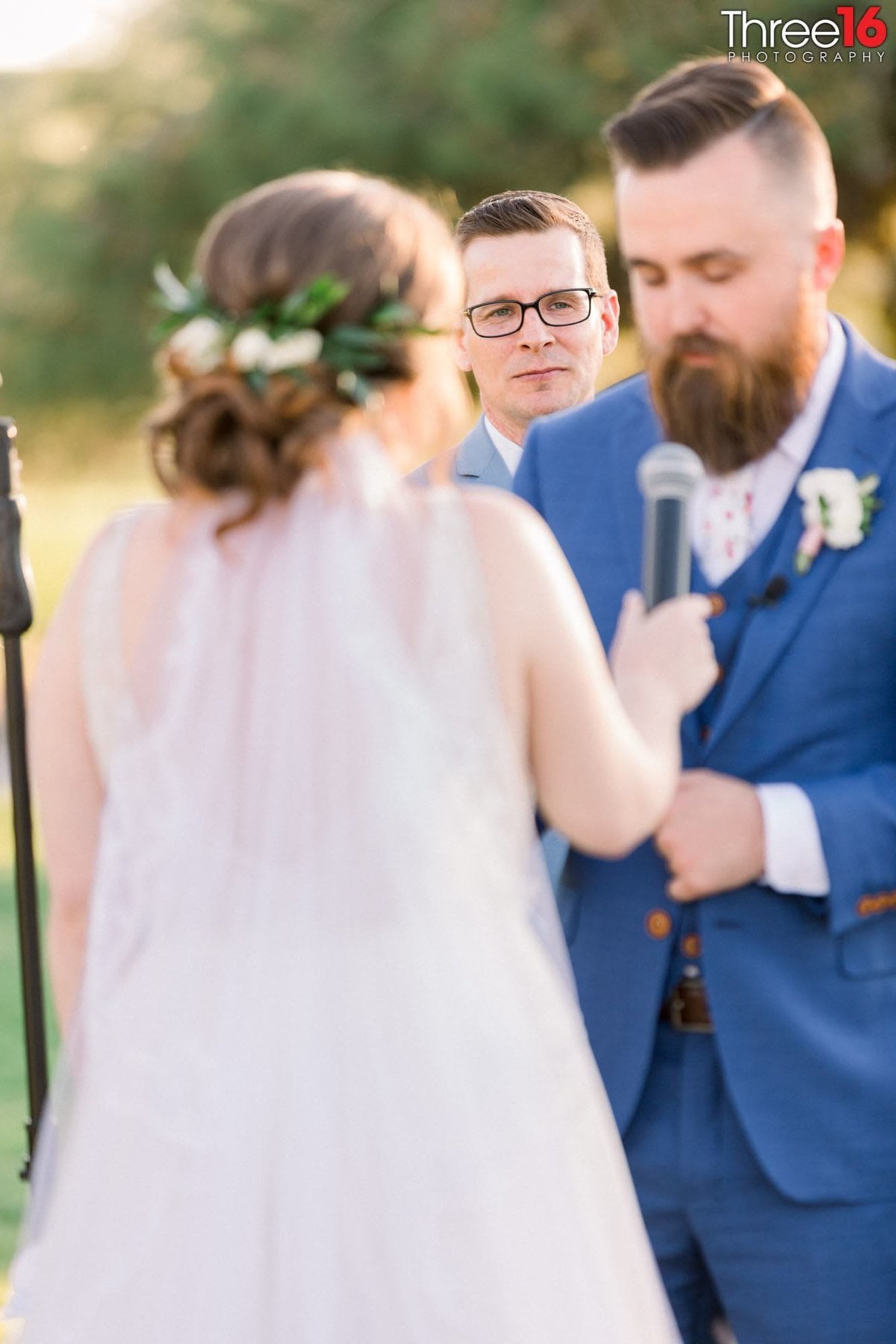 Bride holds the mic as Groom reads his vows