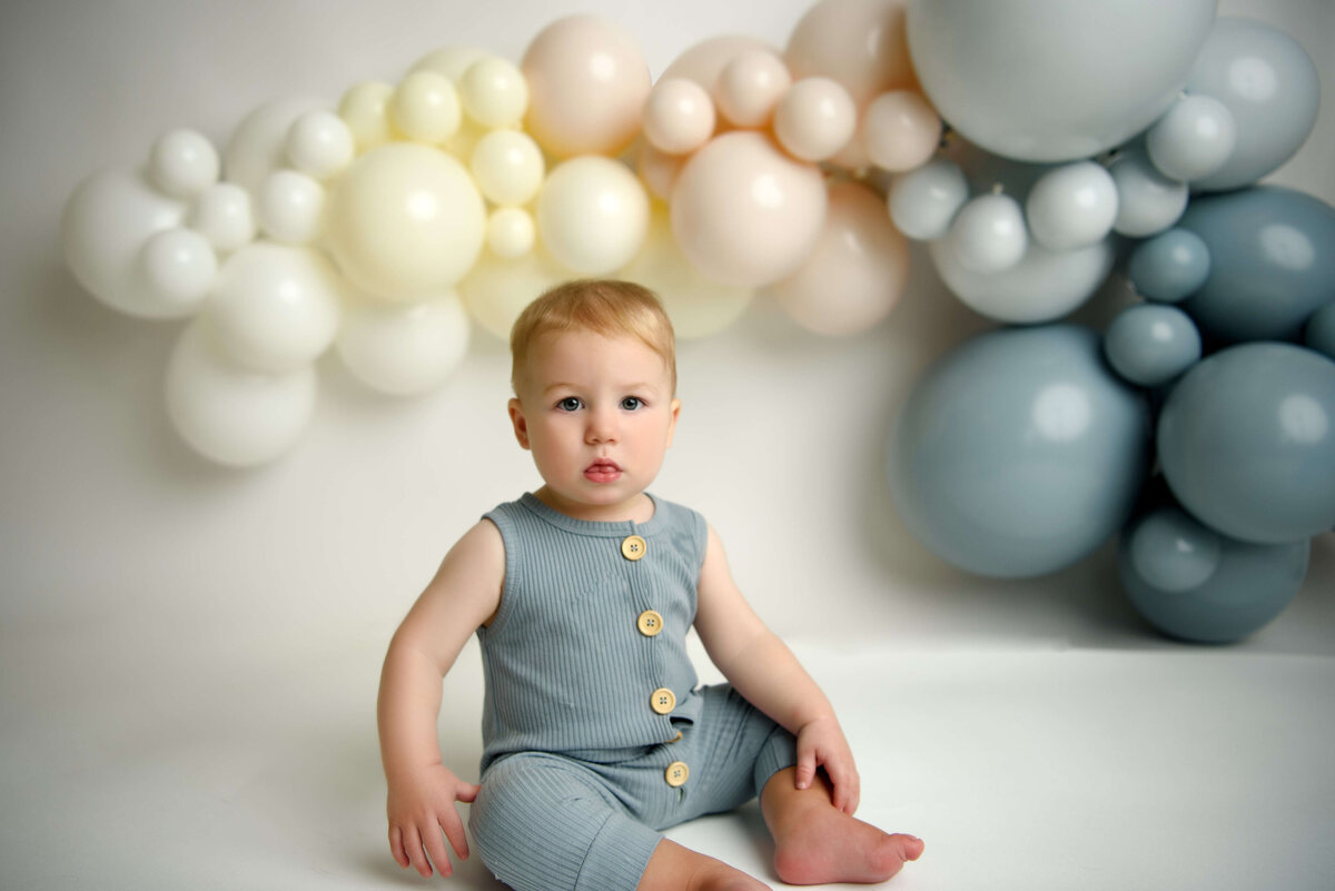 One year old baby in front of ballon arch