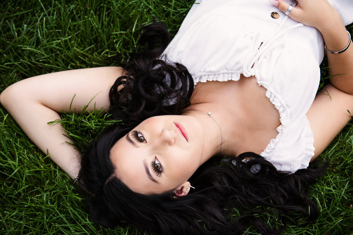 girl in white dress laying in grass