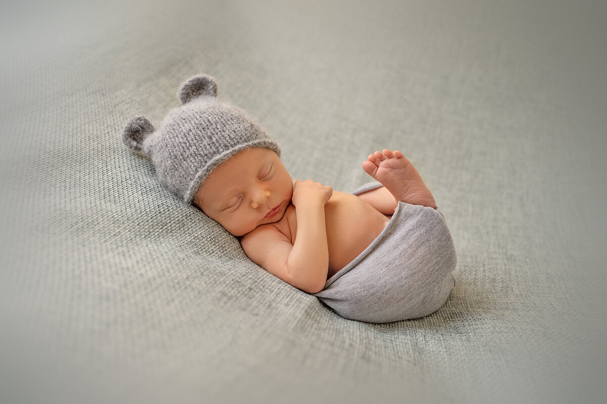Newborn baby in wrap and little hat with ears
