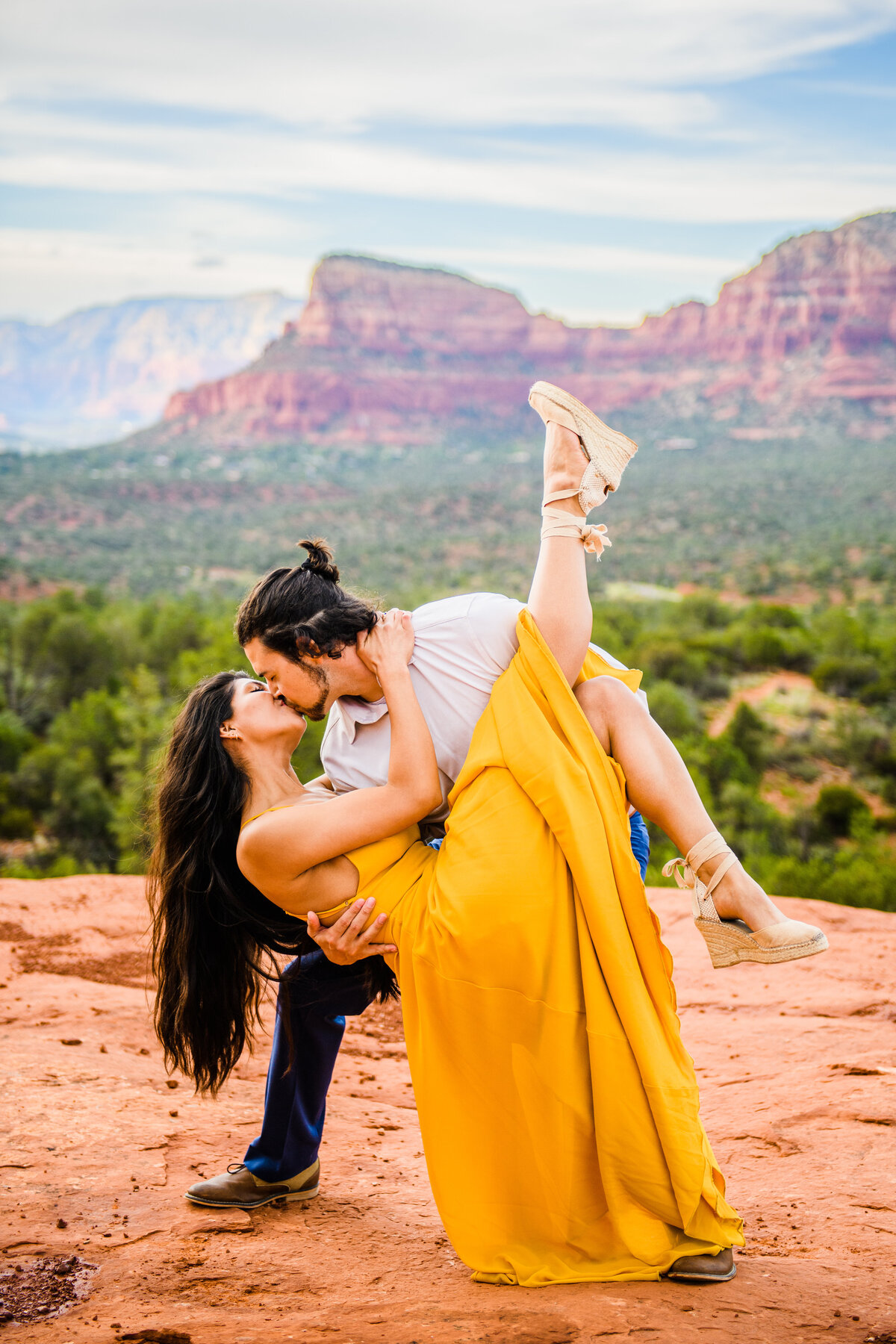 Couple engaged dancing dip kiss Sedona red rocks engagement photos yellow dress