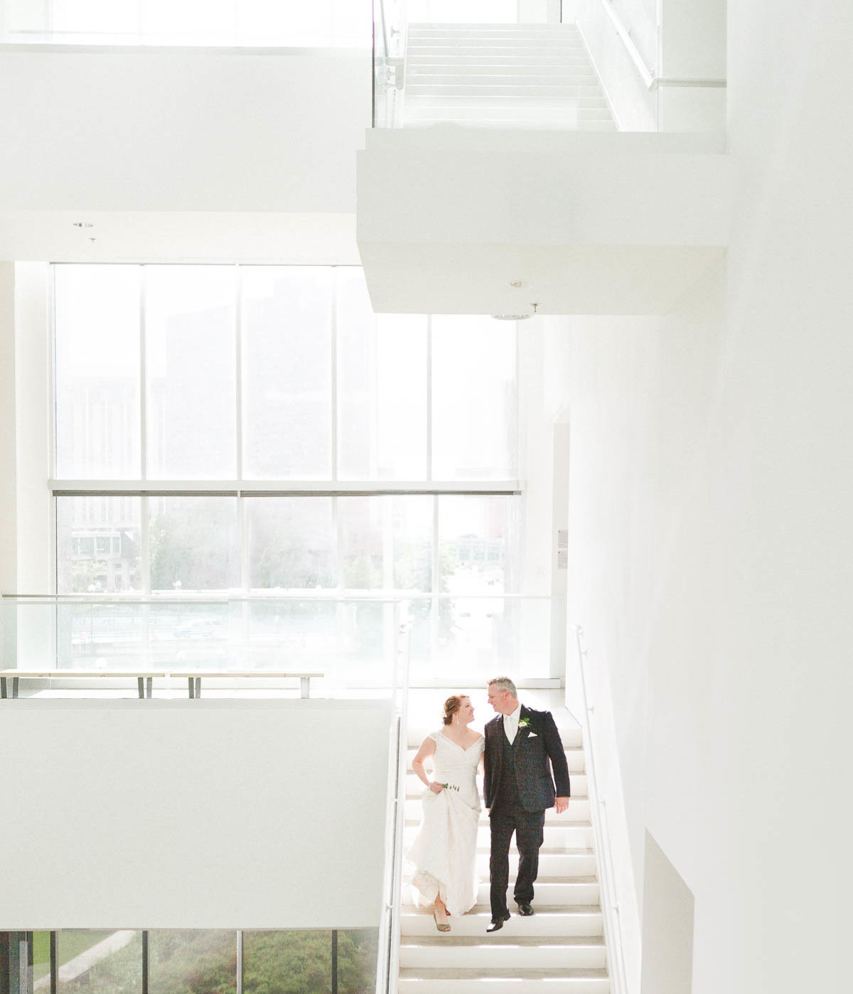 bride and groom descend stairs of rochester art center minnesota
