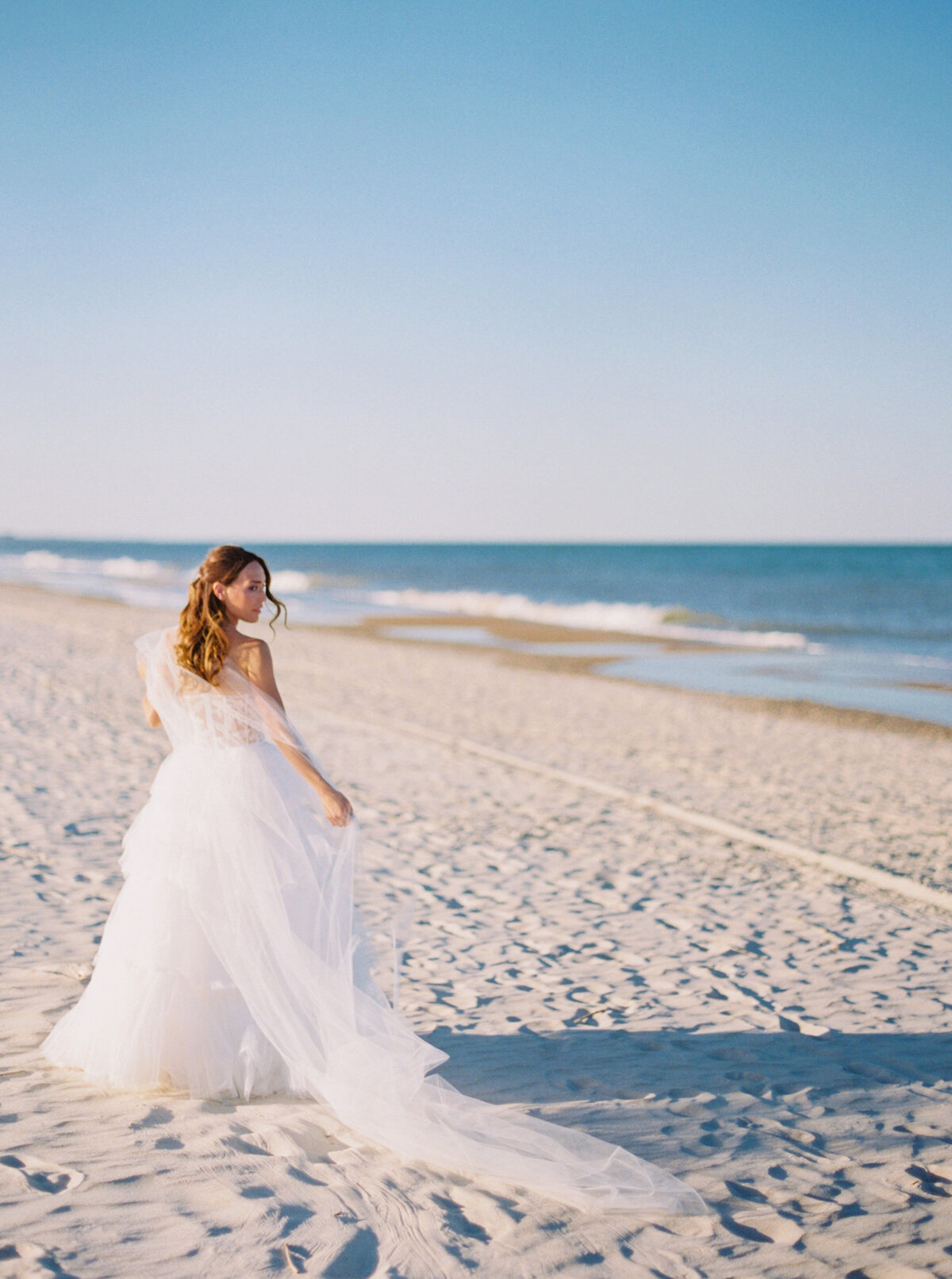 Bride walks along the beach