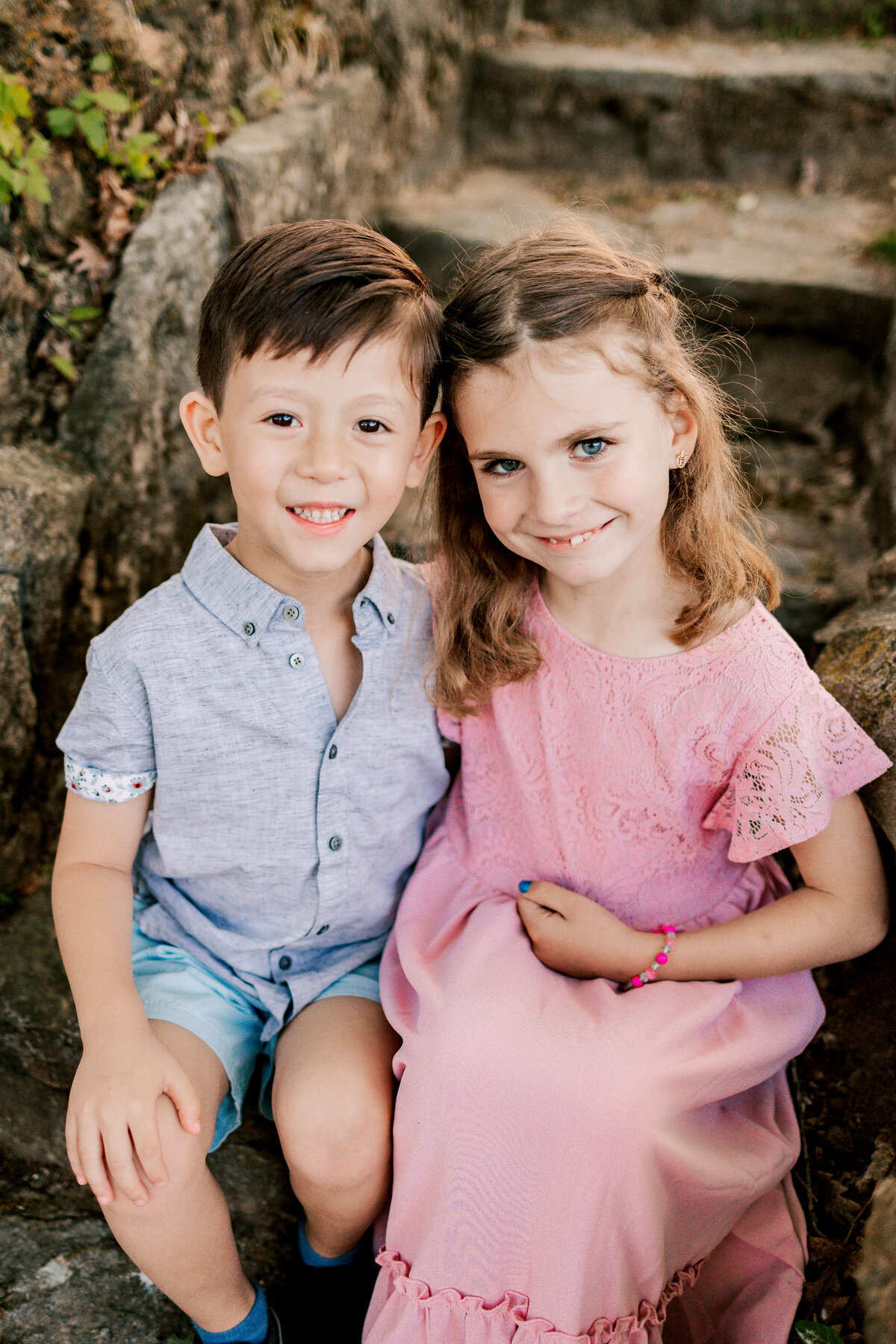 Two adorable kids sitting on stone steps in Silvan Springs Park in Oakville, MO.