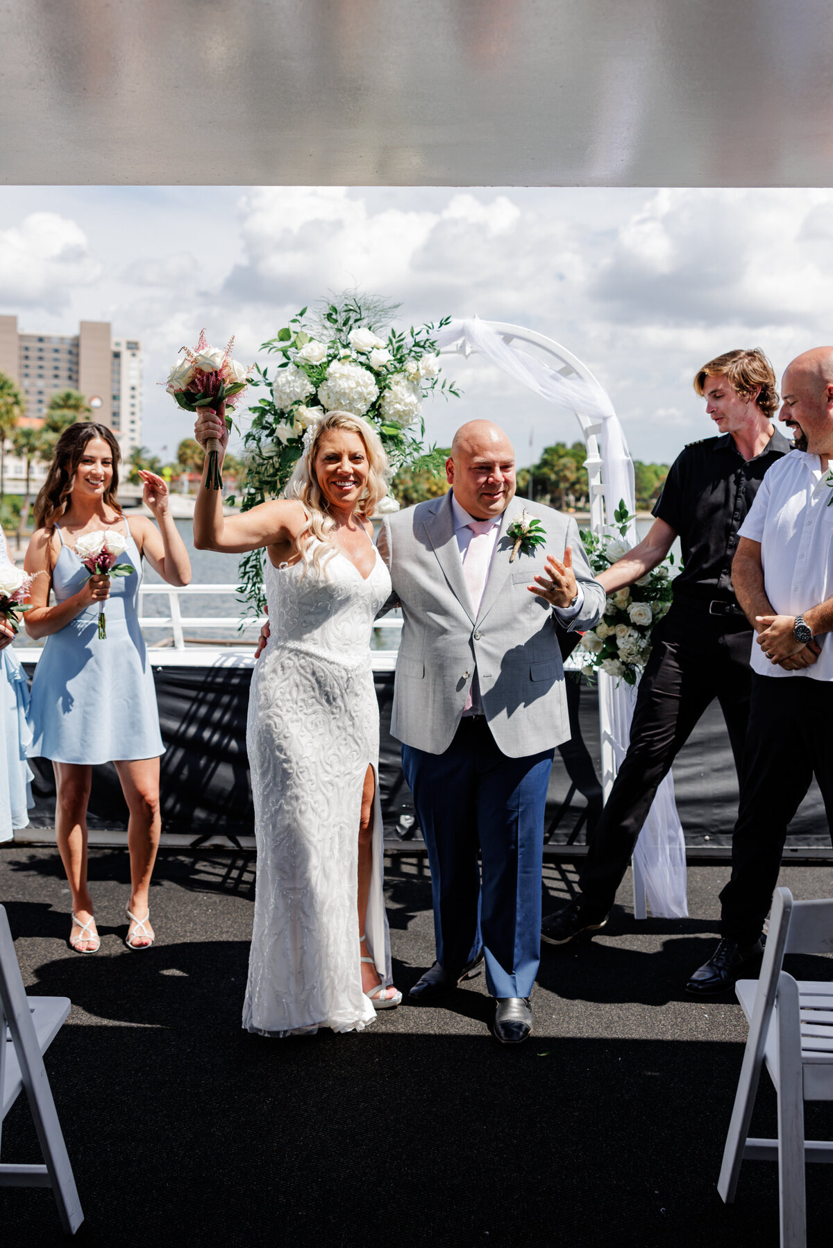 Couple walking hand in hand on Starlite Cruises yacht with St. Petersburg skyline behind them.