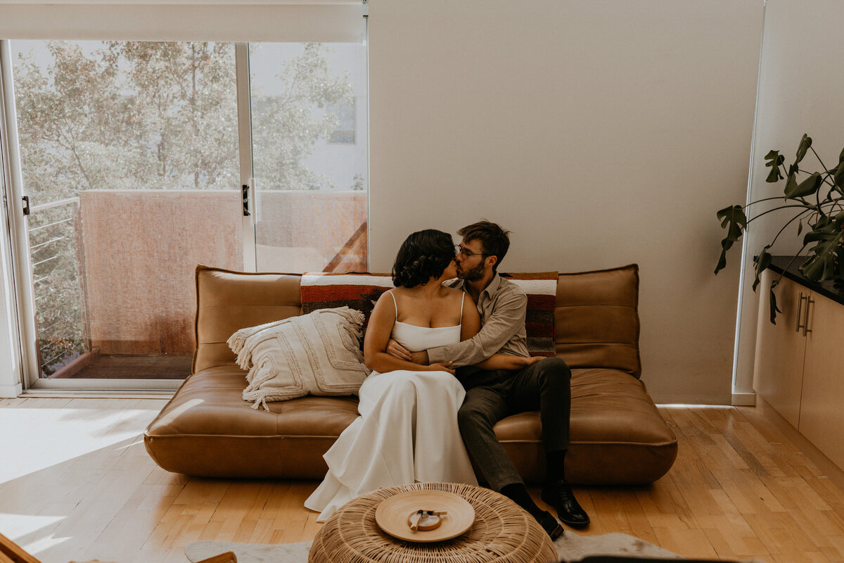 bride and groom sitting on a couch together before their wedding