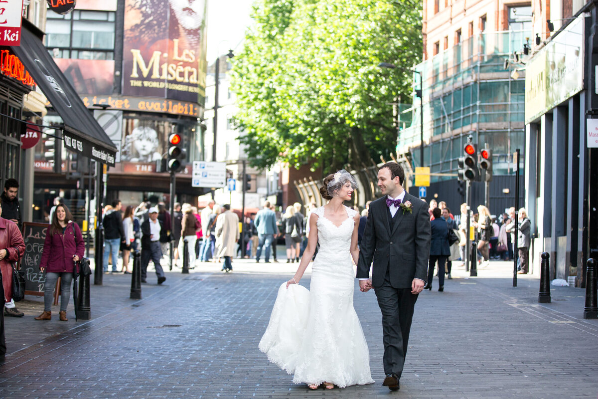 Bride and groom walking through streets of London
