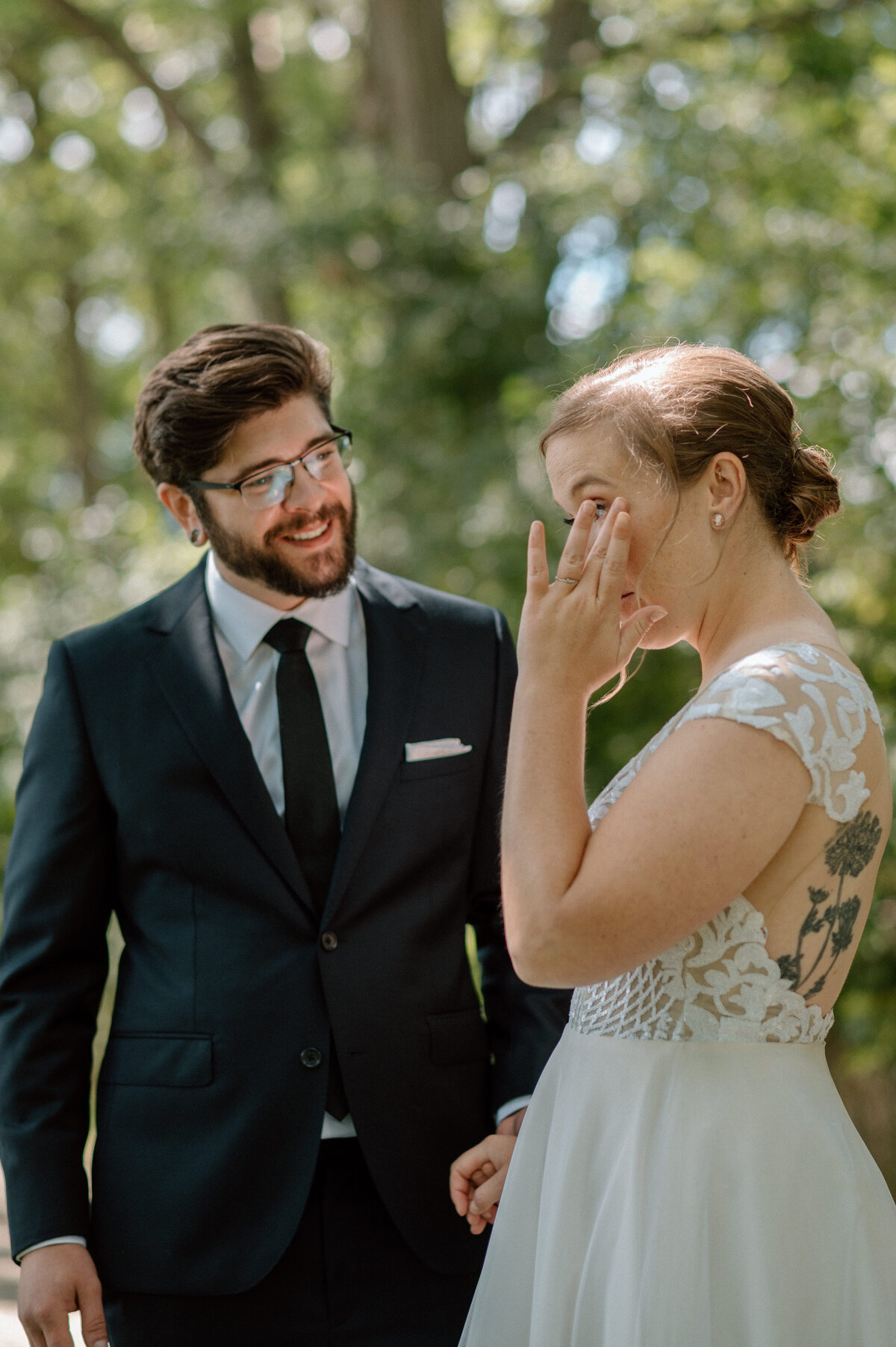 bride wipes away tears during first look