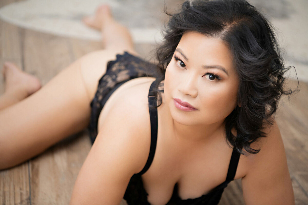 Sultry boudoir portrait of Asian woman posing on floor
