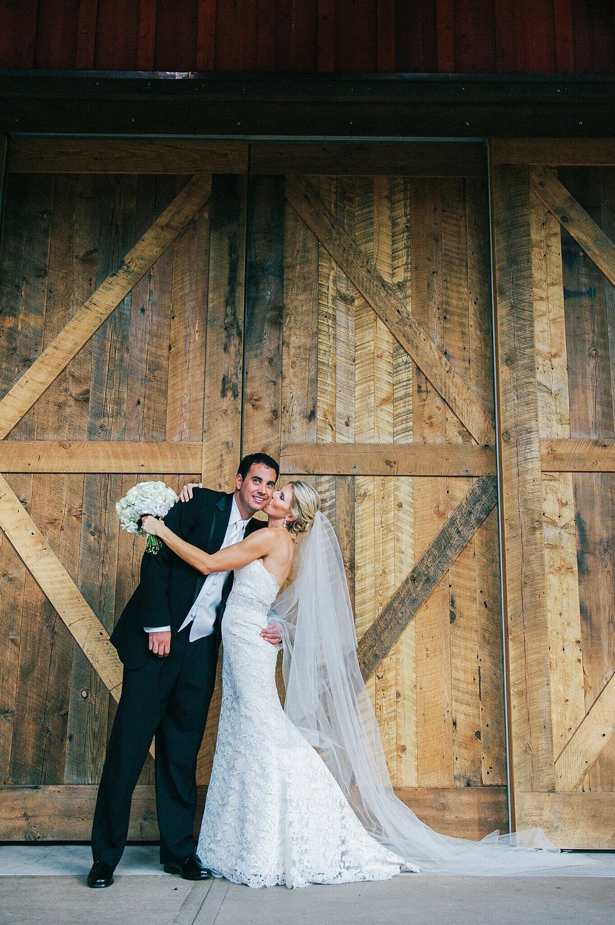 couple  posing at barn in Martis Camp