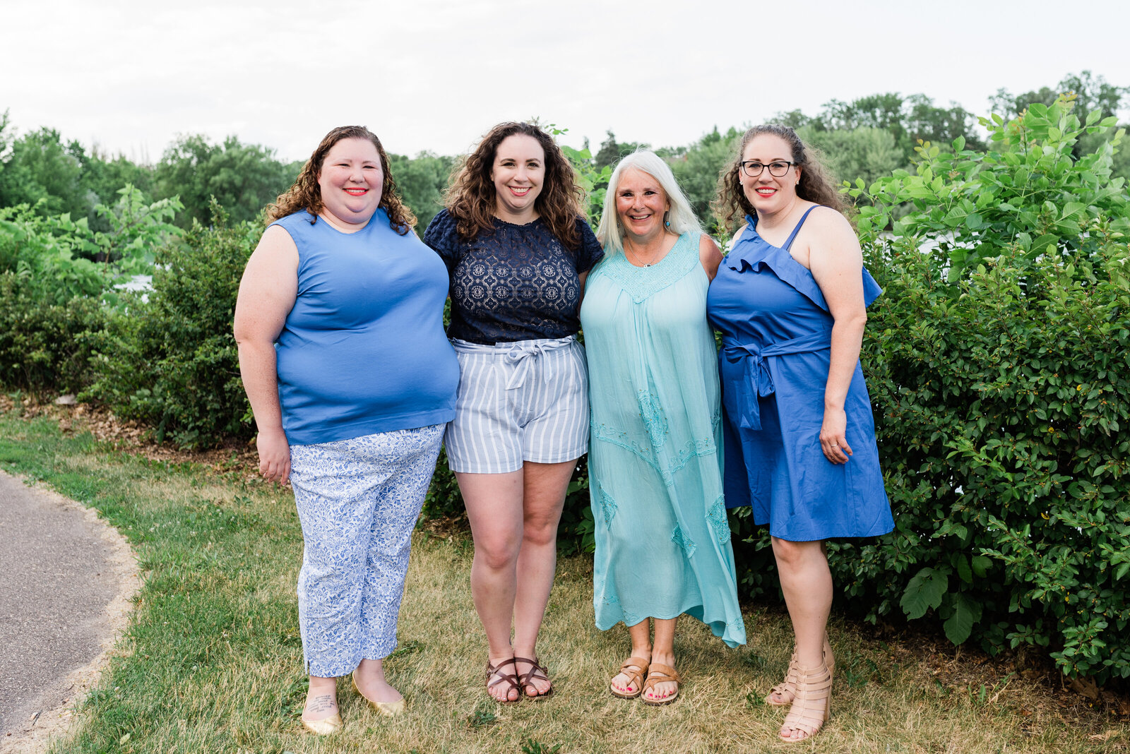 Three daughters and mother dressed in blue smiling