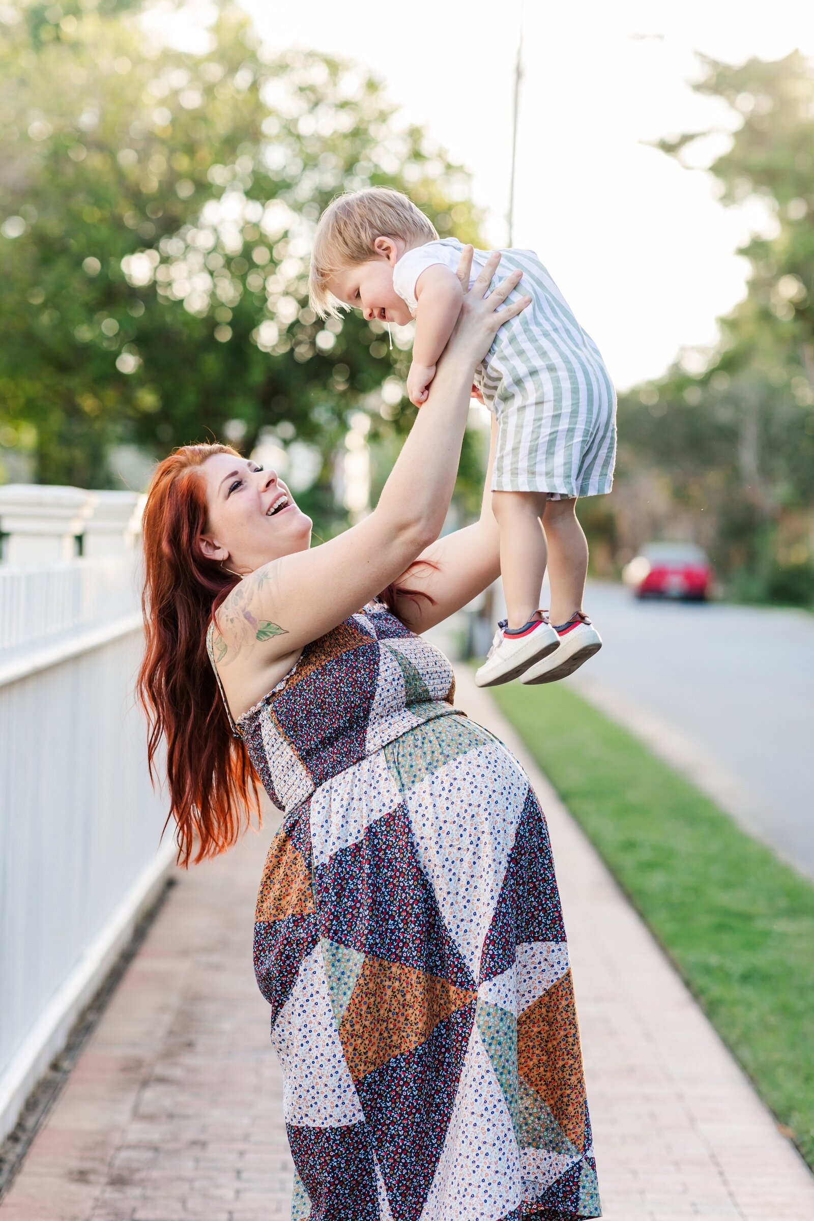 Downtown Pensacola Family Photography session with family of 4. Mom tossing son into the air.