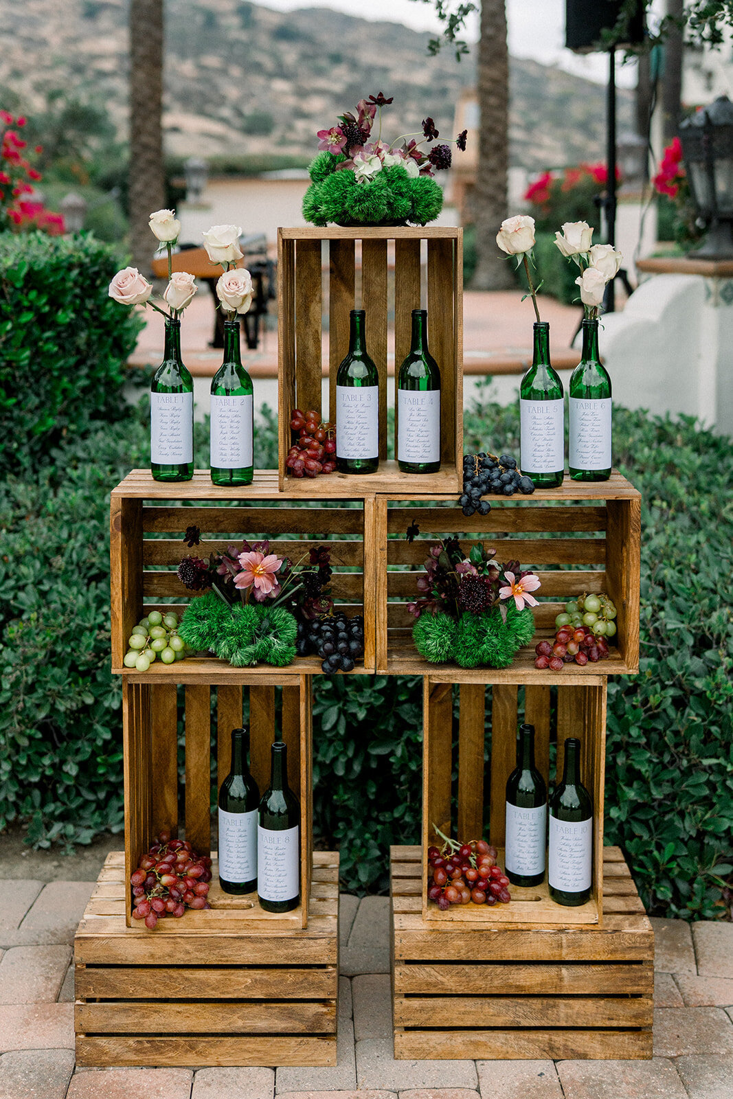 Whimsical wedding bar with vintage bottles and florals at luxury Los Angeles wedding, photographed in soft documentary style.