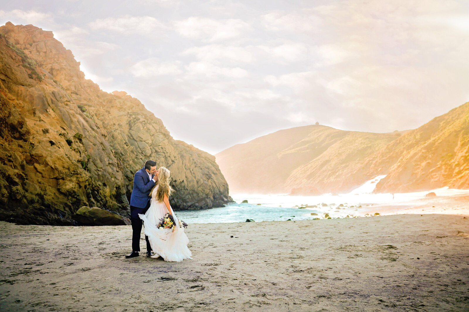 Luxury Big Sur Coastal Wedding Photography Bride and groom embracing on the beach during romantic Big Sur wedding in California