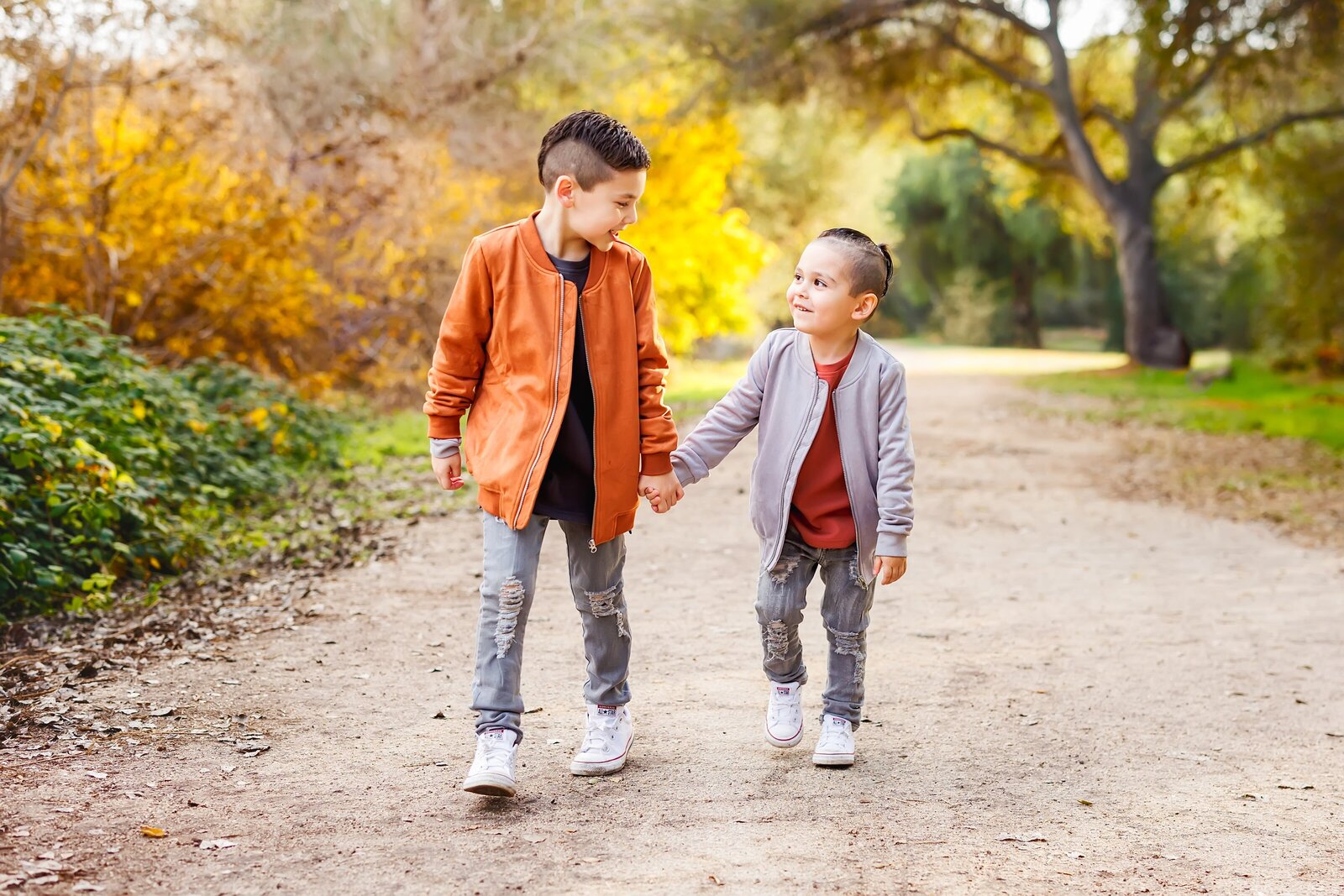 Two young brothers holding hands and walking on a trail at Felicita Park in Escondido