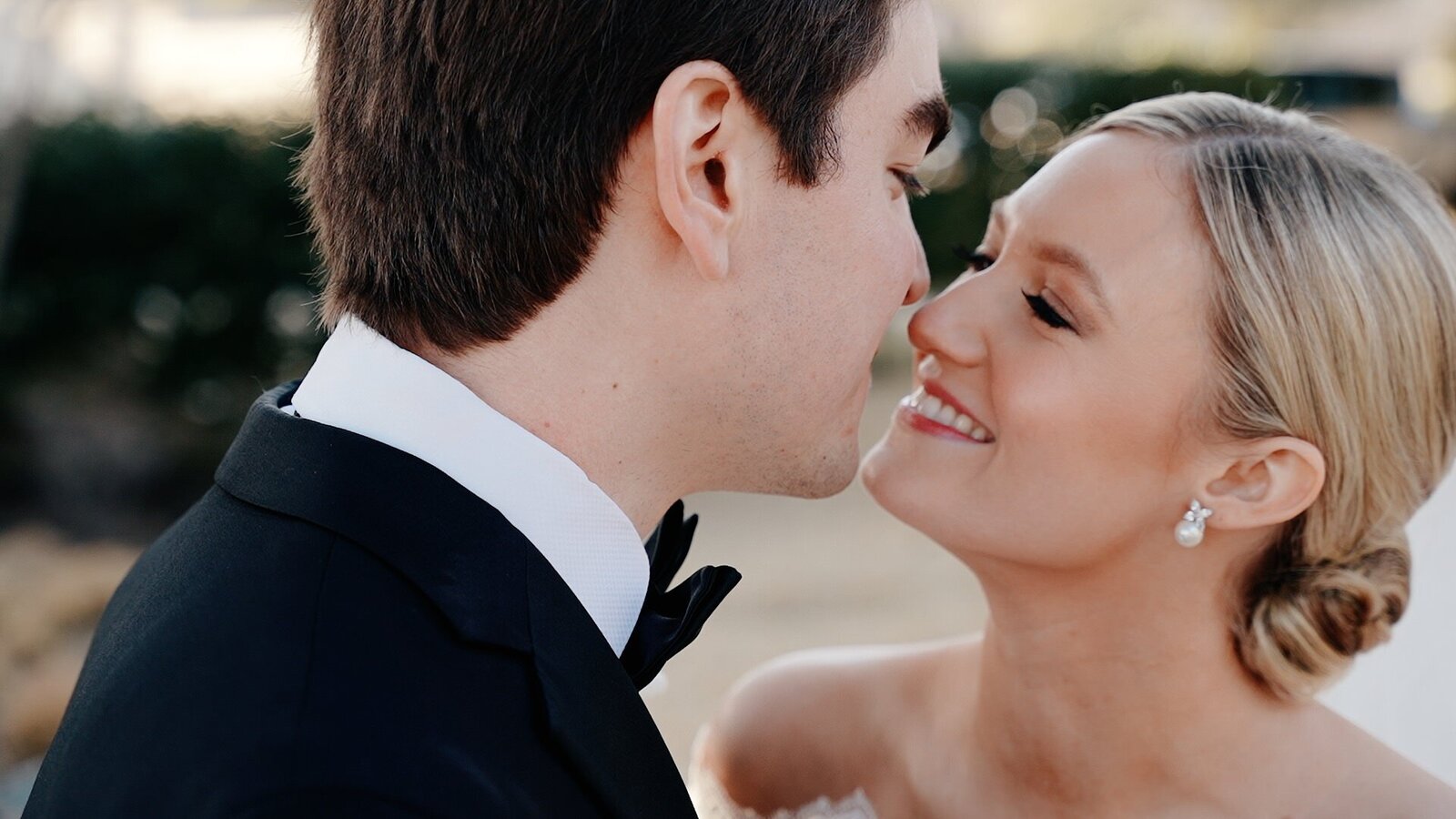 A Texas wedding videographer captures a sweet moment of a bride and groom sharing a kiss on the cheek.