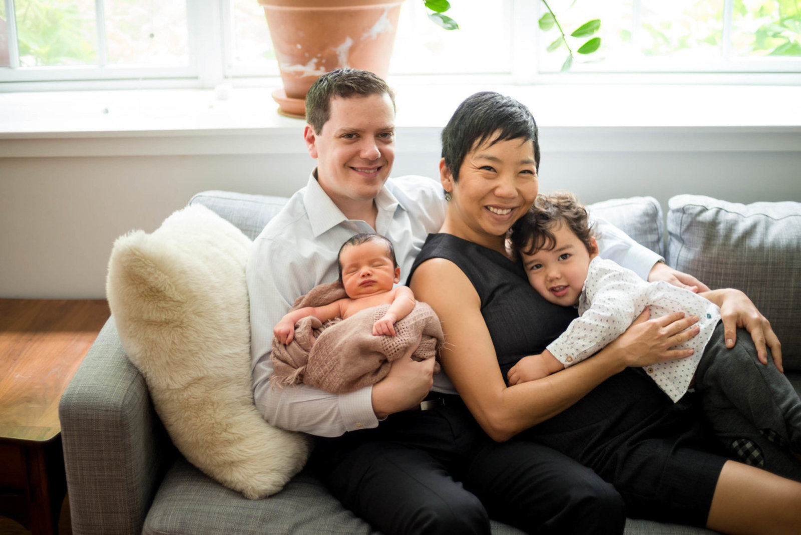 parents hugging newborn at home lifestyle session family photo