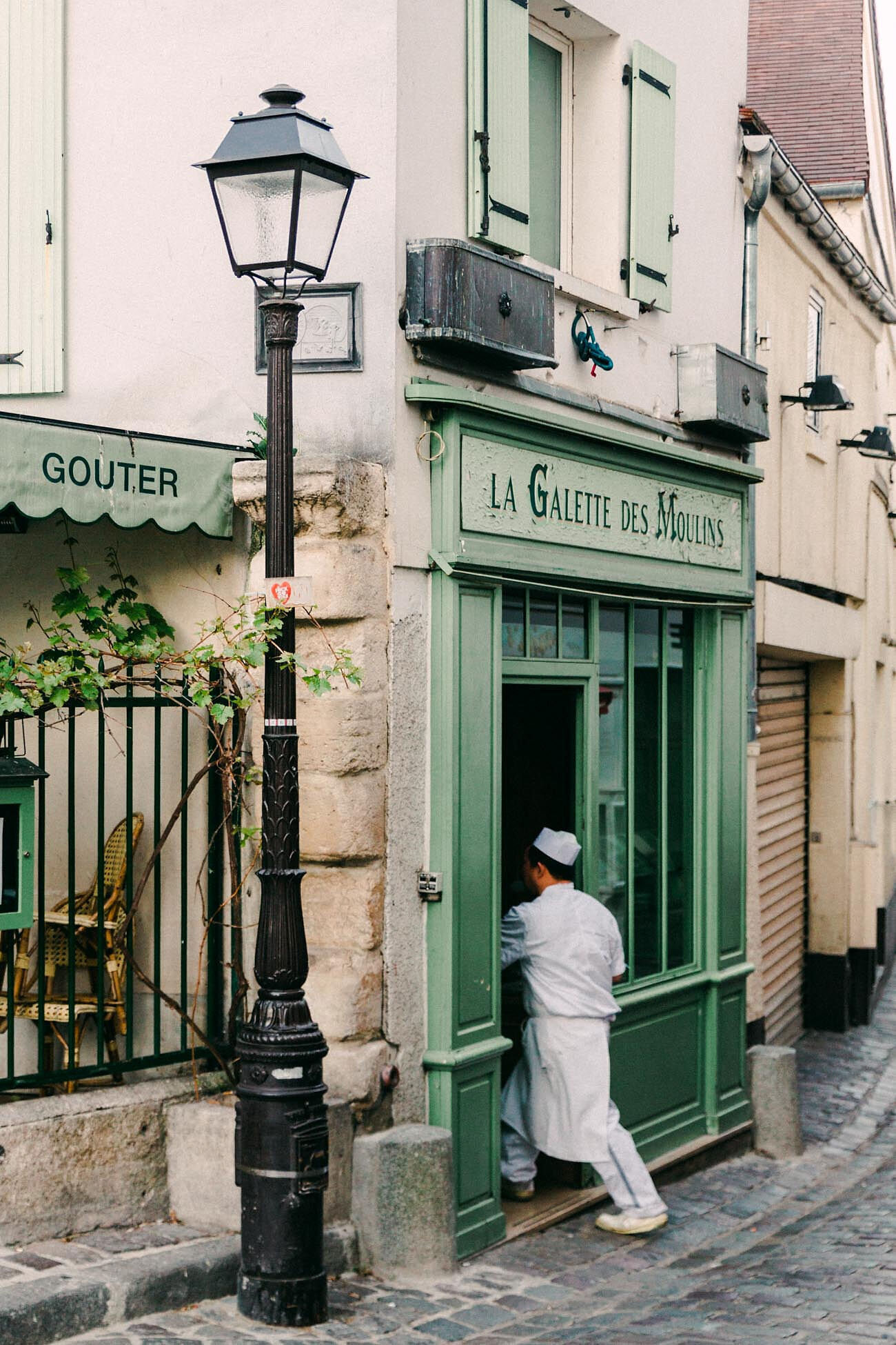 Baker walking into boulangerie in Paris, France, by branding photographer Chelsea Loren