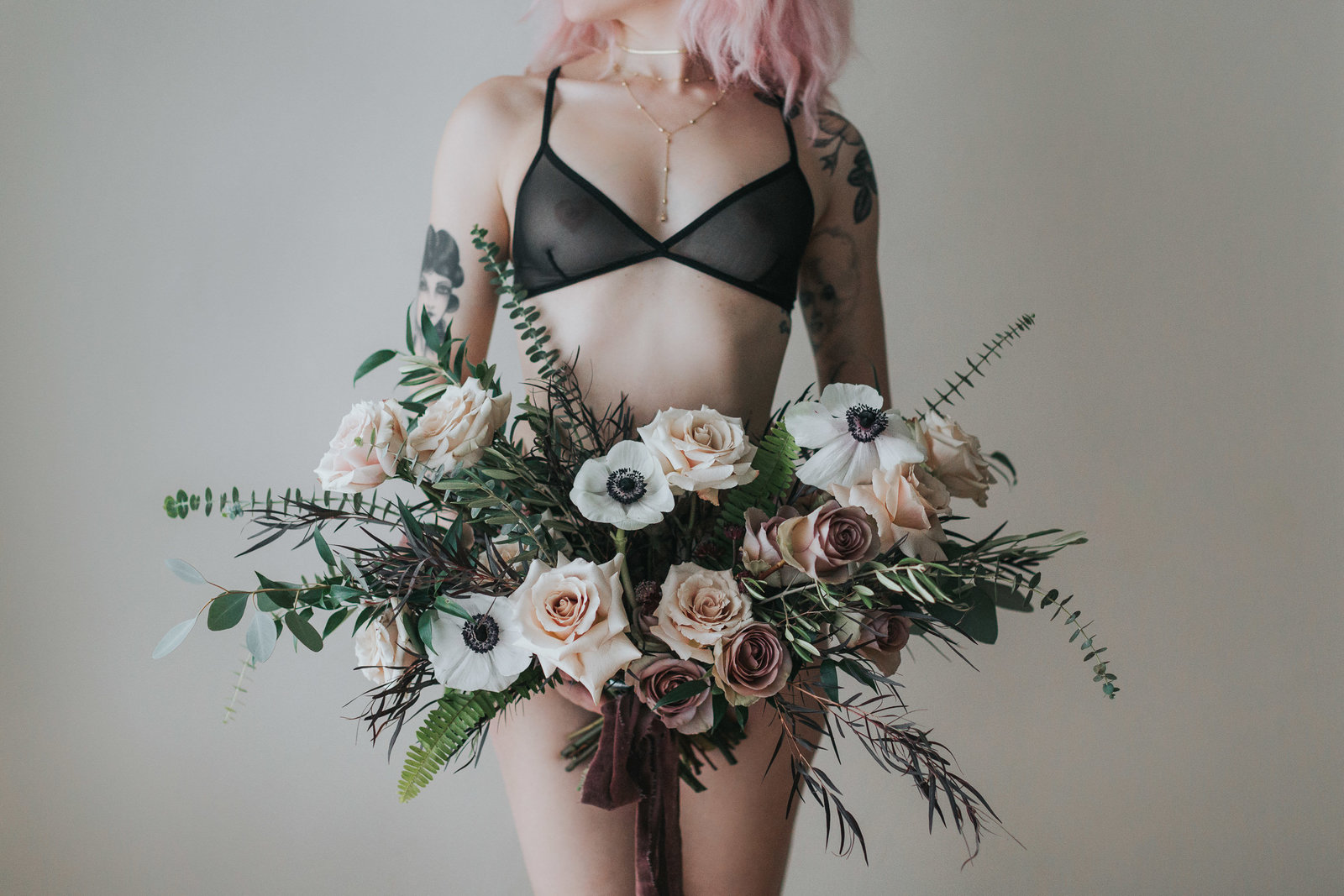 Girl in lingerie holding bouquet of flowers