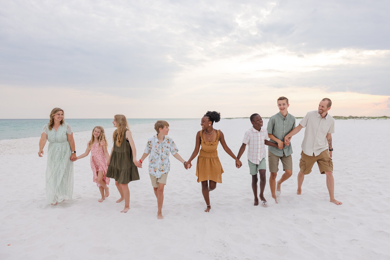 Family of 8 walking down Pensacola Beach during beach vacation photo session with Jennifer Beal Photography