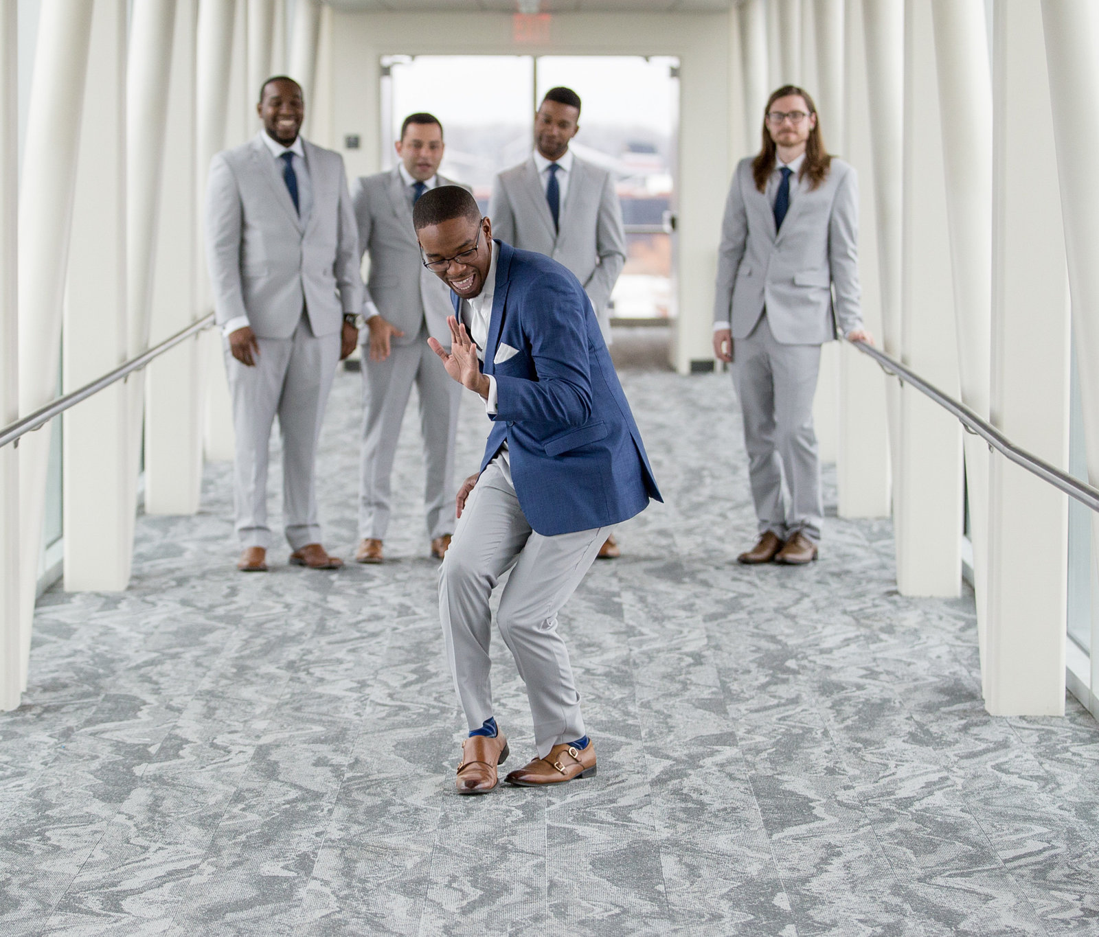 Groom dances down the skybridge at Sheraton Erie Bayfront Hotel while his groomsmen look on