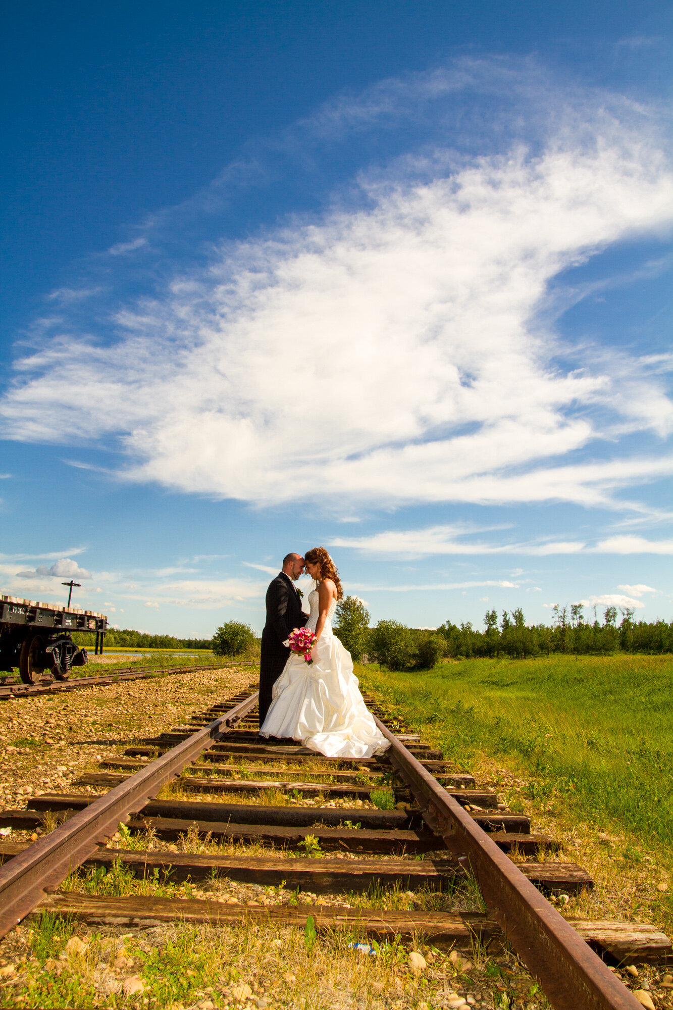 Bride and Groom leaning in, touching forheads on tracks at Ukrainian Cultural Village