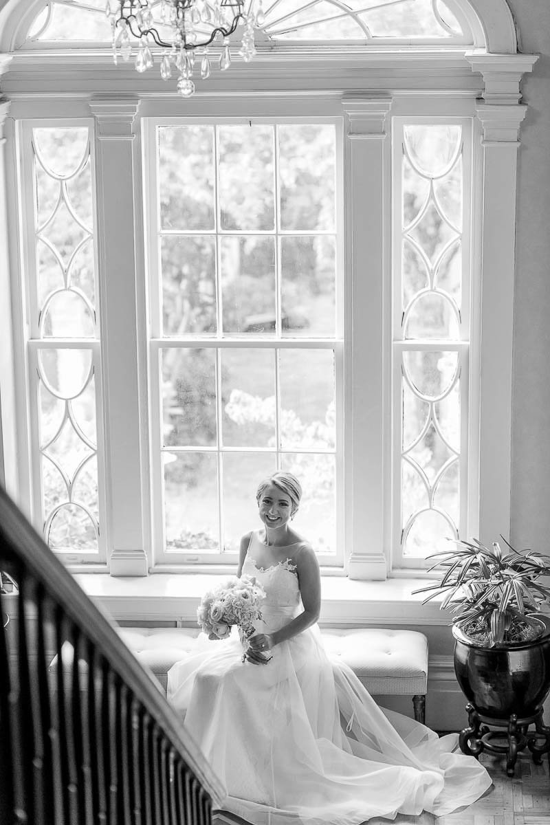 Bride sits in front of window, John Rutledge House Inn, Charleston, South Carolina
