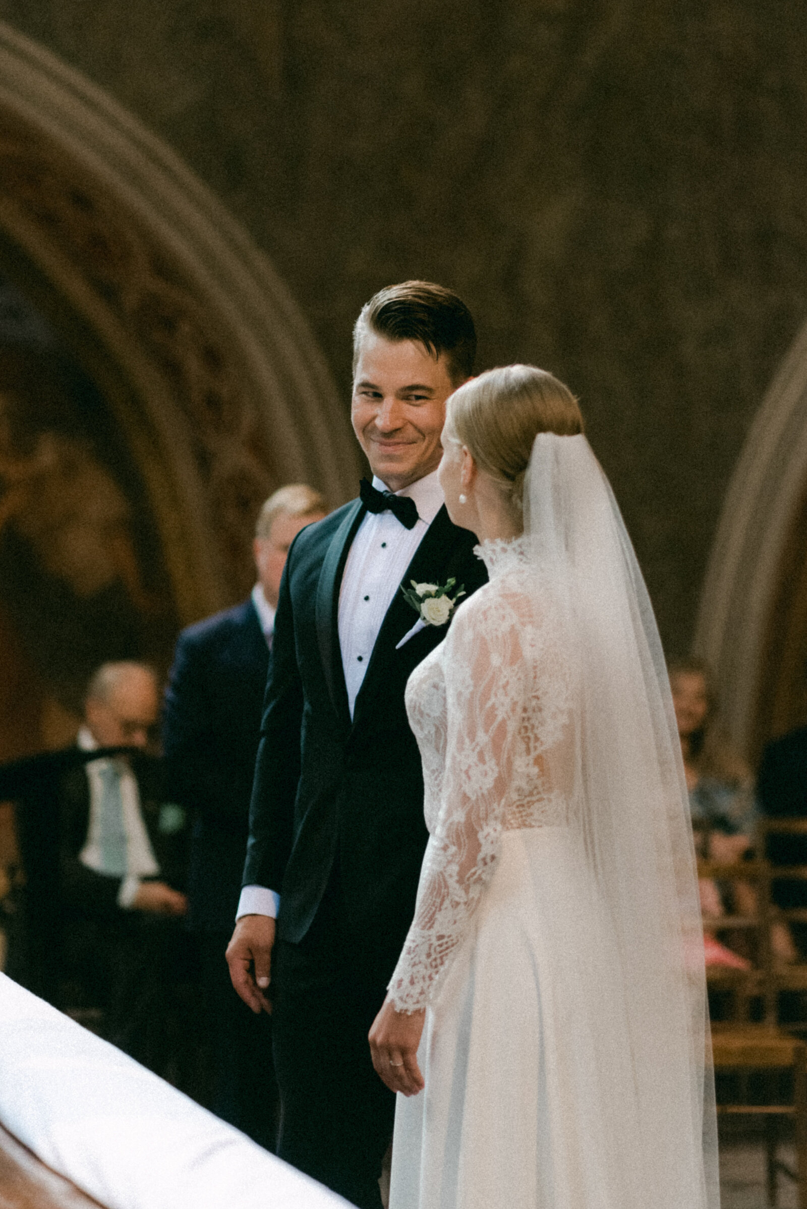 Bride and groom are looking at each other when the bride is saying 'I do' during wedding ceremony in Turku cathedral. Documentary photograph of Scandinavian wedding photographer Hannika Gabrielsson.